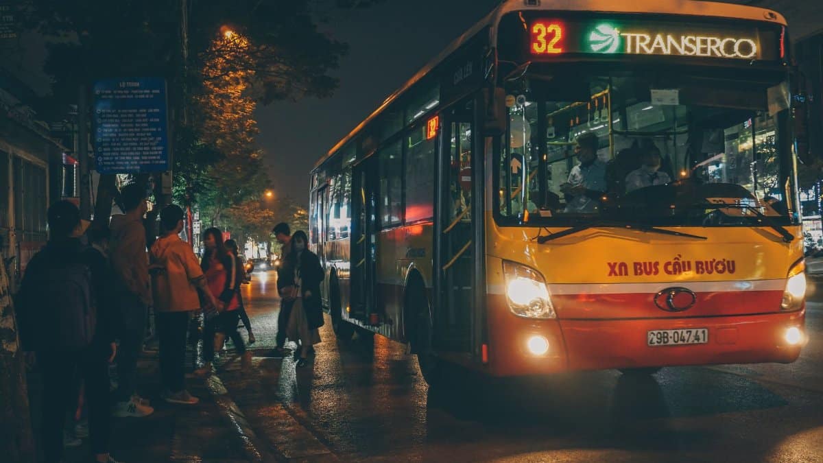 Evening scene of commuters boarding a bus in Hanoi, Vietnam.