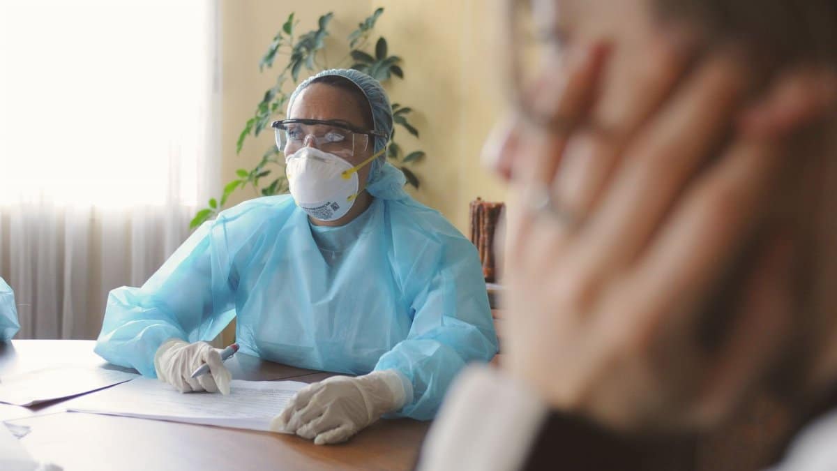 Medical workers in PPE conduct a meeting focused on health procedures.