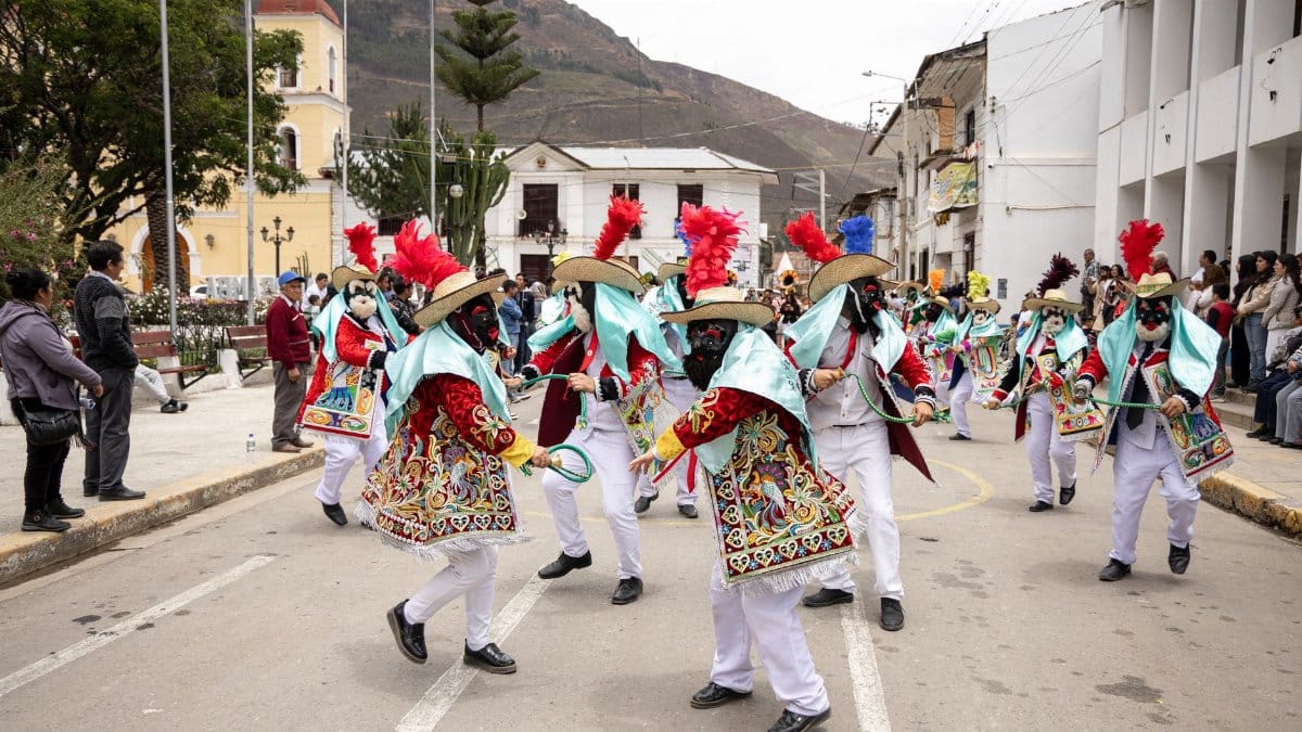 Dancers in vibrant costumes perform at a traditional festival in Peru's streets.