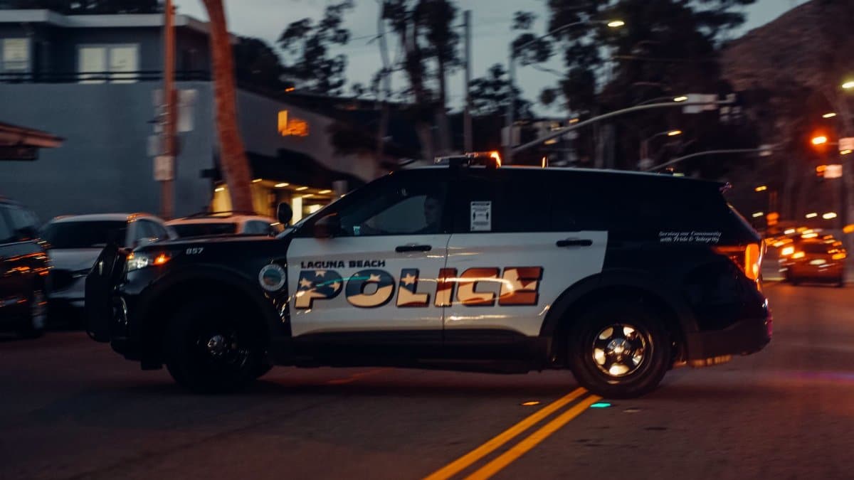 Laguna Beach police vehicle patrols the street at night, showcasing law enforcement presence.