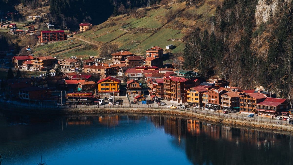 Scenic aerial view of Uzungöl village surrounded by lush mountains and a tranquil lake, Trabzon, Türkiye.