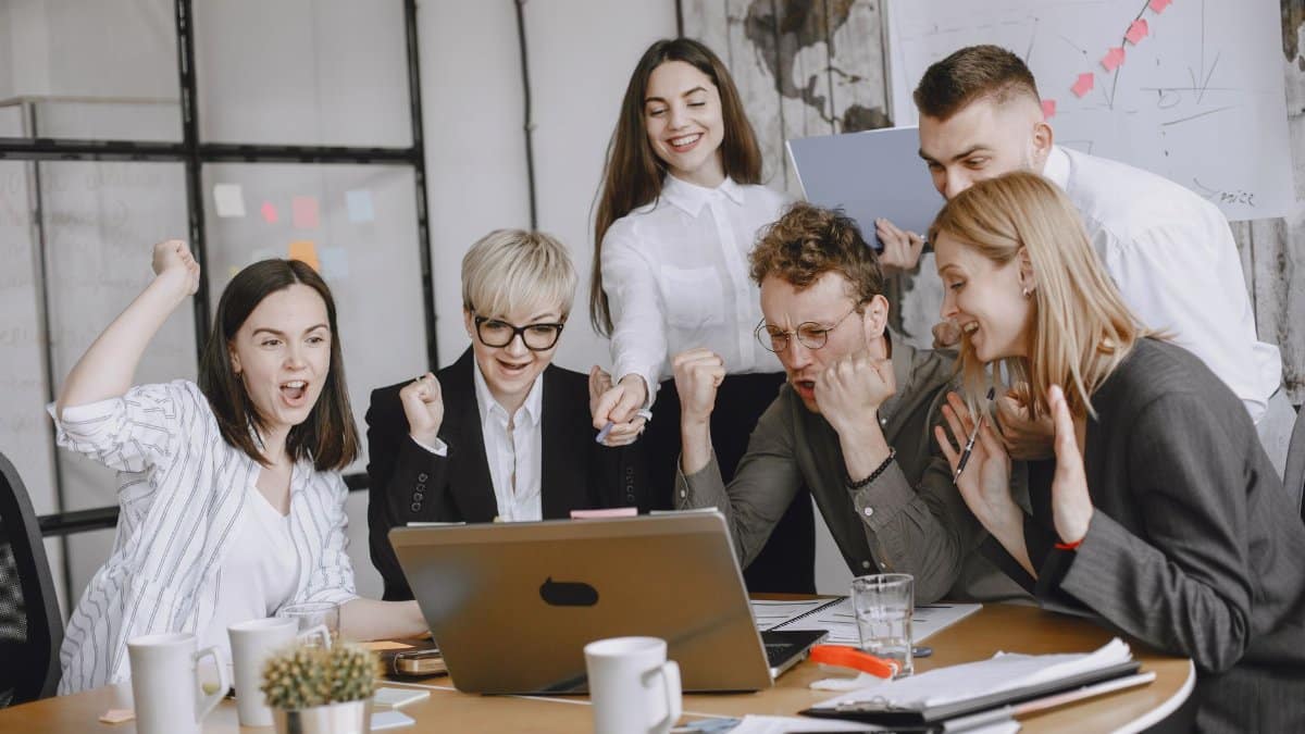 Group of diverse colleagues celebrating success in a modern office