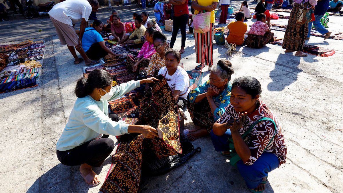 A lively scene at Maumere's traditional market showcasing local textiles and diverse communities.