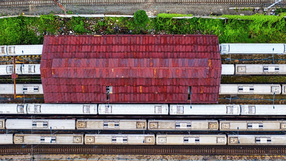 An aerial view showcasing commuter trains and tracks at a Jakarta railway yard.