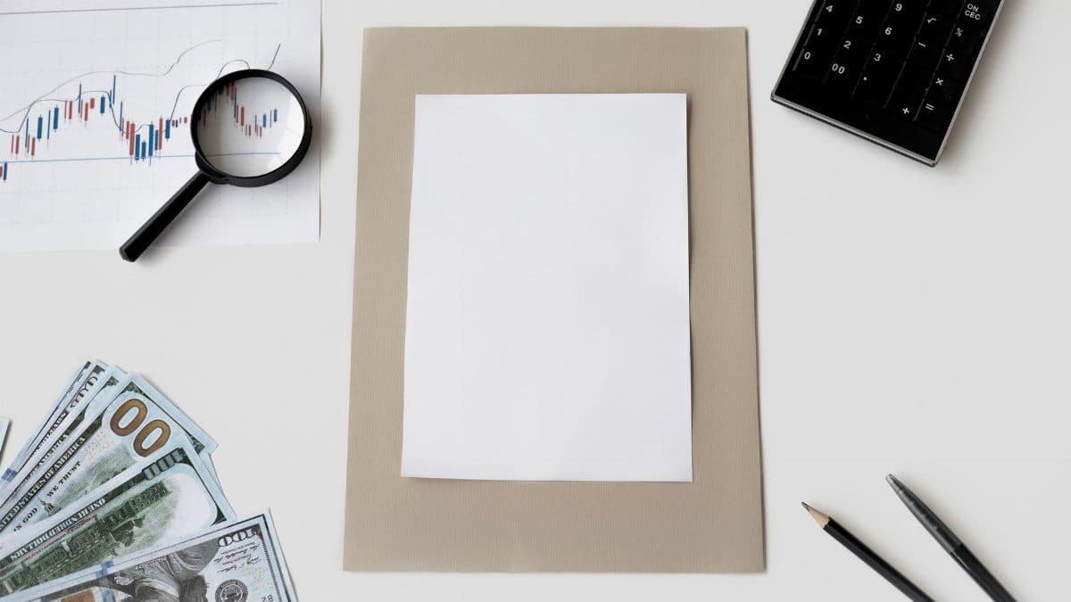 Flat lay of financial tools and blank paper for planning or mockup.