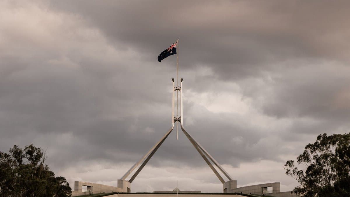 The Parliament House of Australia in Canberra with a dramatic cloudy backdrop.