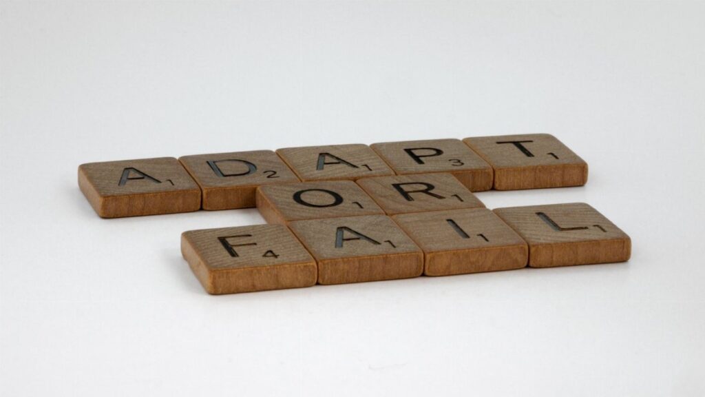 Scrabble tiles spelling 'Adapt or Fail' on a plain background, symbolizing decision-making.