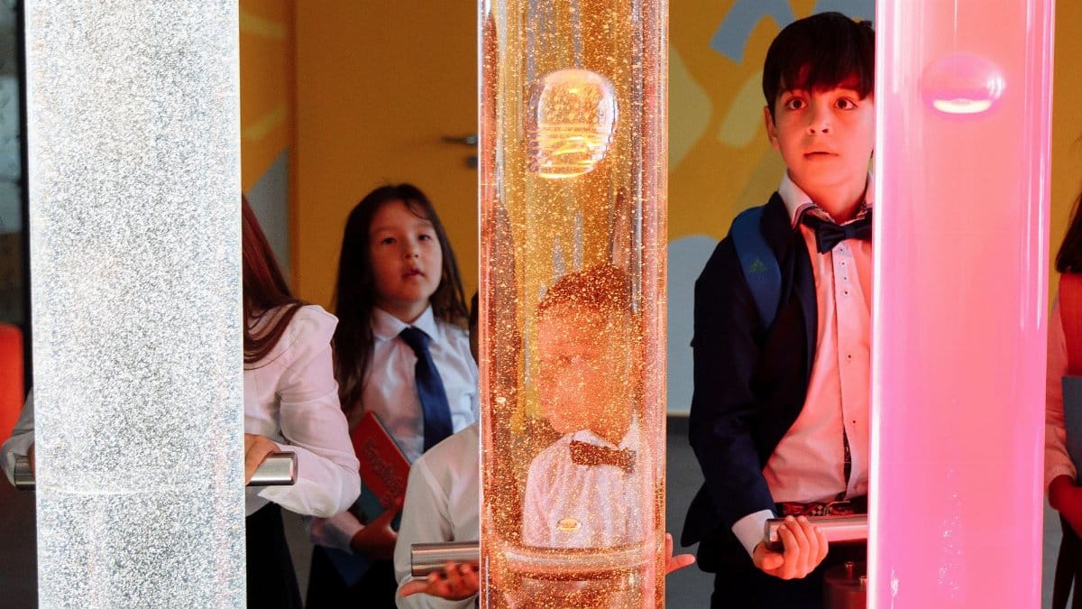 Kids engaging with a colorful science exhibit, sparking curiosity and learning through hands-on interaction.