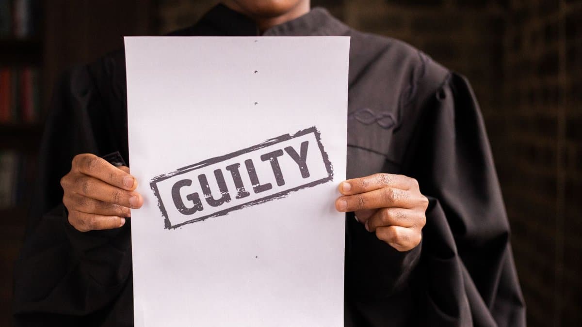 A judge in a courtroom holding a paper with a guilty verdict, symbolizing law and justice.