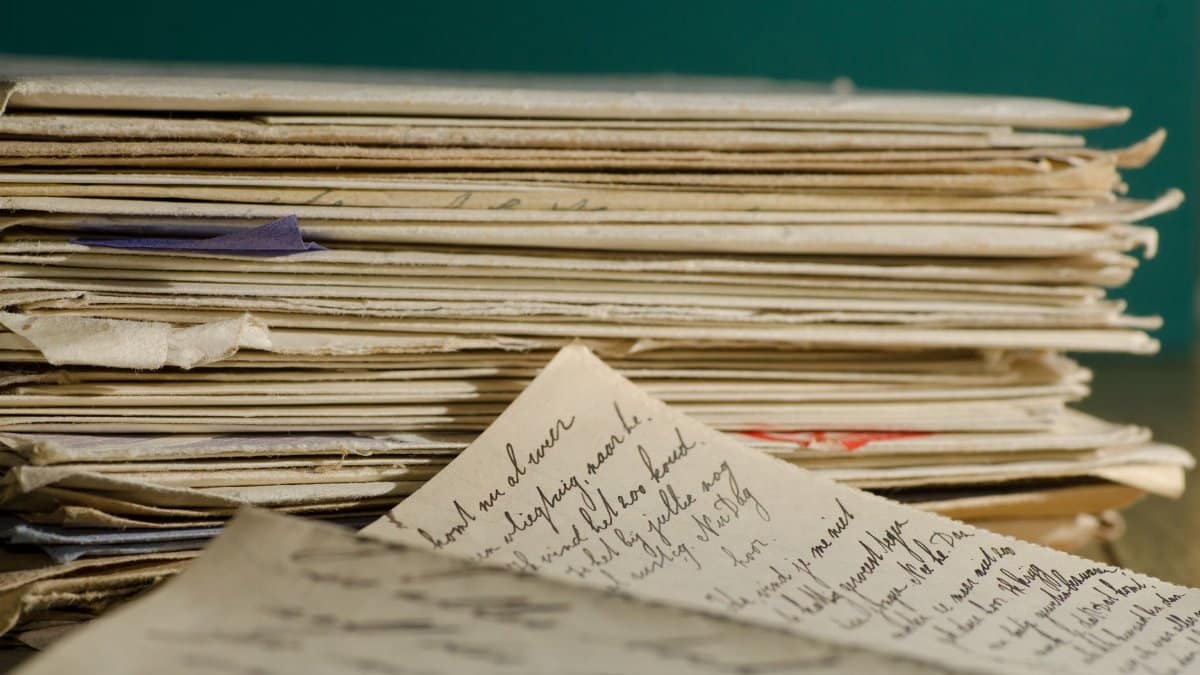 Close-up image of handwritten letters and papers stacked together, conveying a vintage feel.
