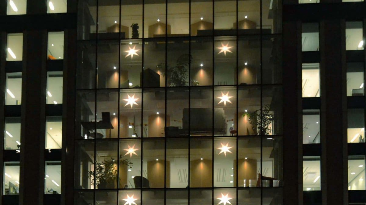 Night view of an office building in Stockholm decorated with Christmas lights and stars.