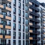 Contemporary apartment building with balconies in urban setting, showcasing modern architecture.