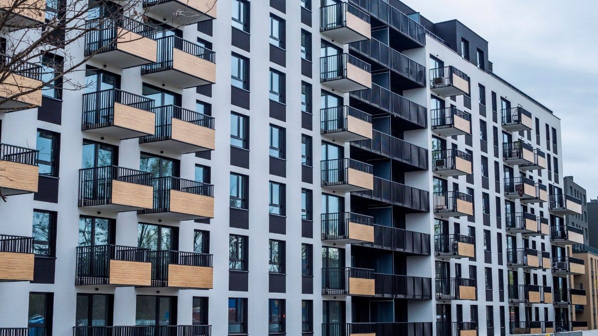 Contemporary apartment building with balconies in urban setting, showcasing modern architecture.