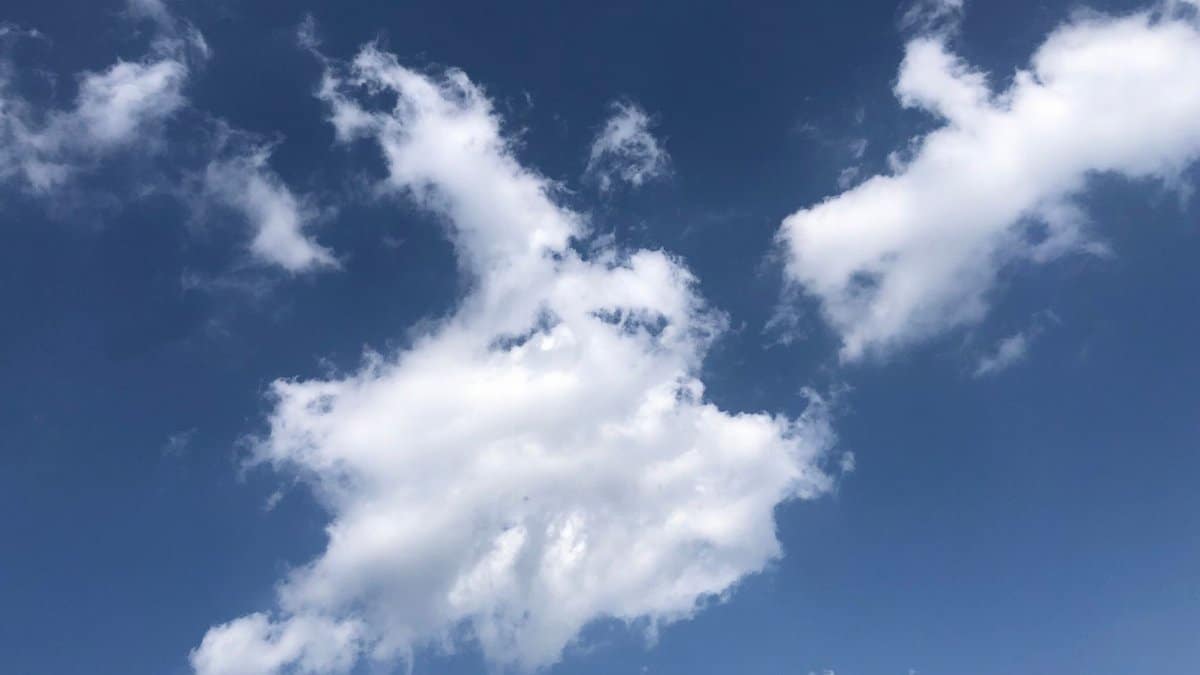 Beautiful fluffy clouds set against a clear blue sky during a sunny day.