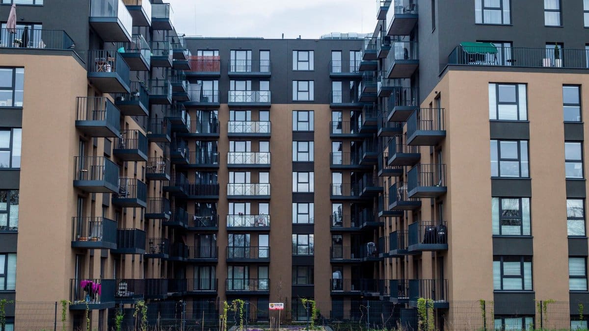 Contemporary apartment building facade with balconies in an urban setting.