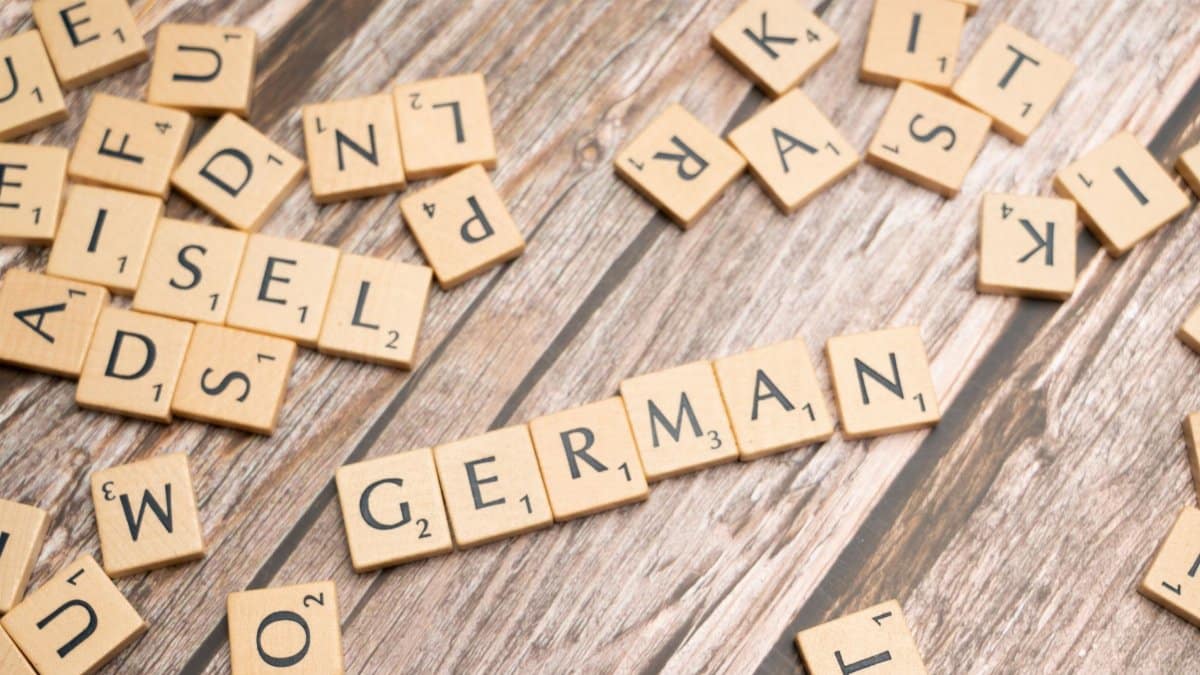 Wooden letter tiles on a table spelling out 'German'. Perfect for language, culture, or typography themes.