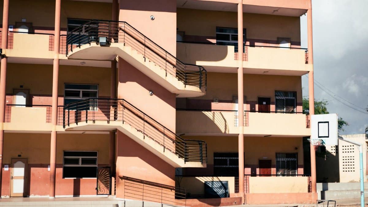 Colorful residential building with outdoor basketball court and external staircases.