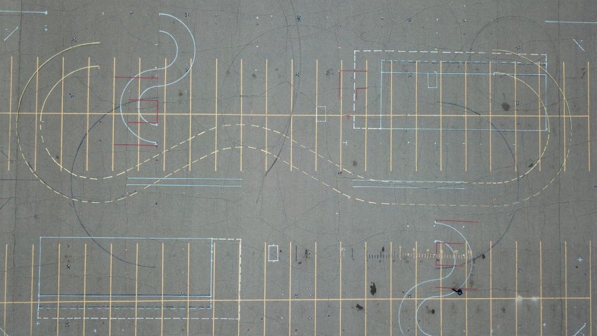 Aerial view of an empty parking lot featuring intricate road markings and parking lines.