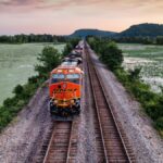 Aerial view of a freight train on a railway through wetlands at sunset near Alma, Wisconsin.