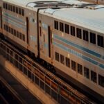 A cinematic view of double-decker trains in an empty New York rail yard at dusk.