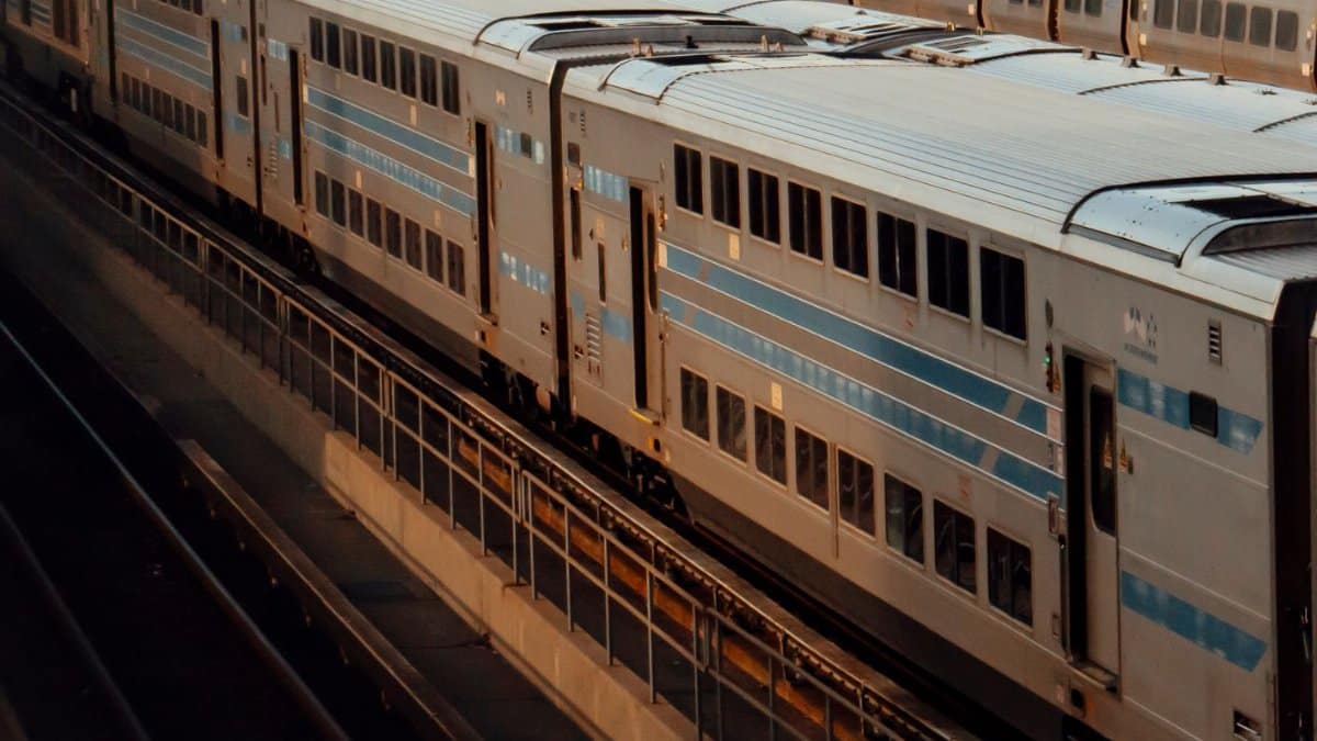 A cinematic view of double-decker trains in an empty New York rail yard at dusk.