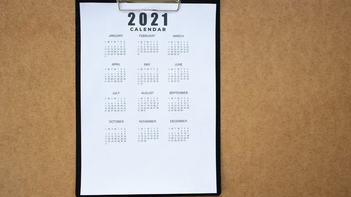 A 2021 calendar clipped to a black clipboard on a brown surface. Ideal for planning or scheduling visuals.