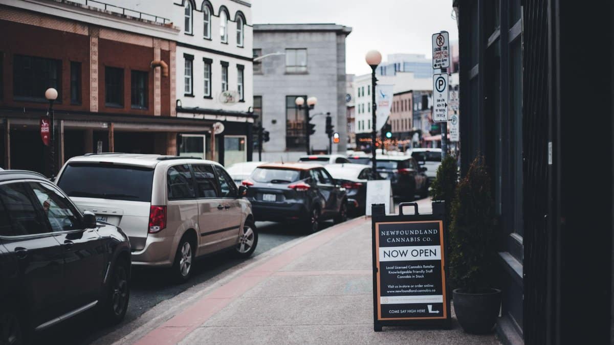 Street view with parked cars and Newfoundland Cannabis Co. sign. Urban day ambiance.
