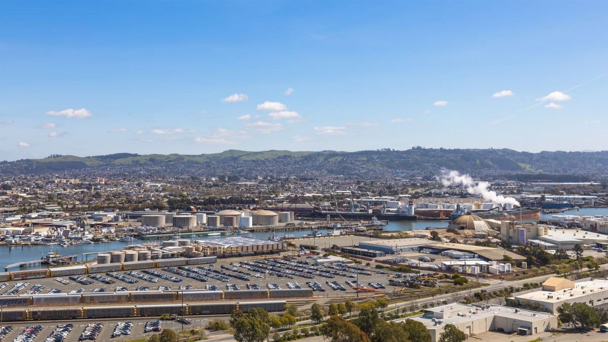 Panoramic aerial view of an urban industrial harbor area with blue sky.