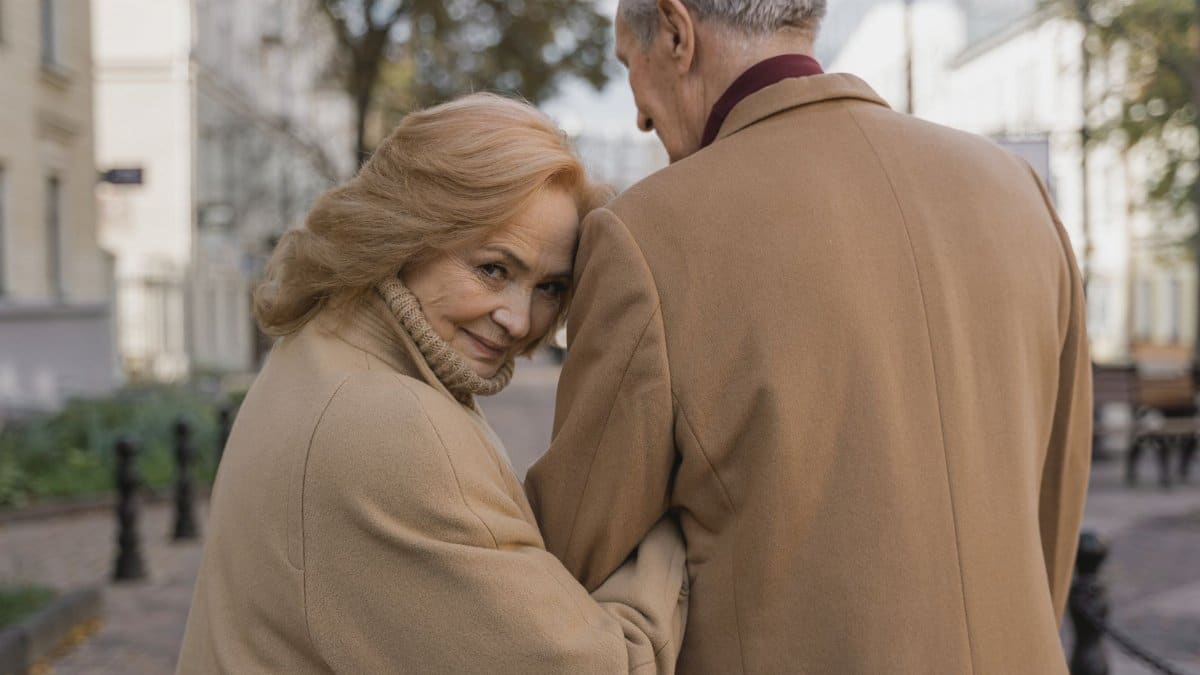 Tender moment of senior couple embracing outdoors in fall, exuding warmth and love.