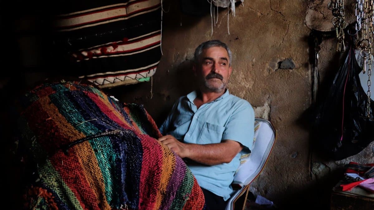 Elderly man engaged in traditional embroidery in Mardin, Türkiye, capturing cultural craftsmanship.