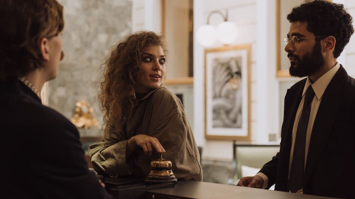 Guests interacting at a luxurious hotel reception desk, emphasizing hospitality and service.
