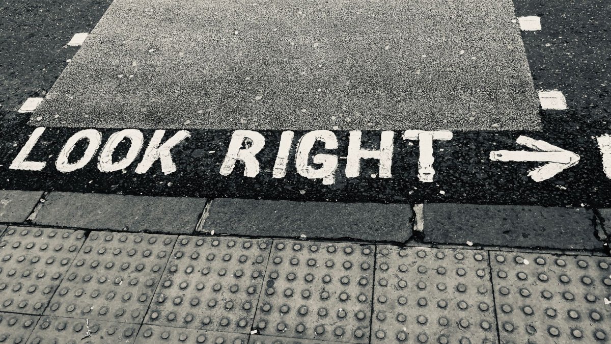 A pedestrian crossing with 'Look Right' painted on concrete, highlighting street safety measures.