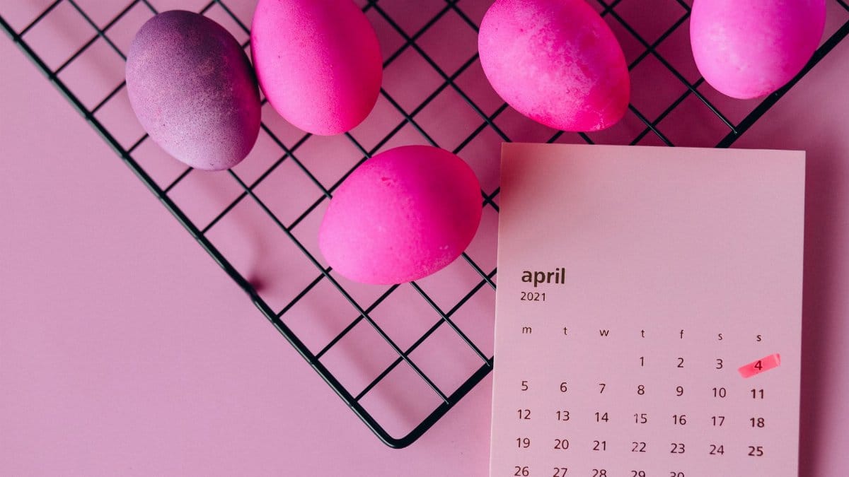 Colorful Easter eggs on a rack and an April 2021 calendar, symbolizing spring celebration.