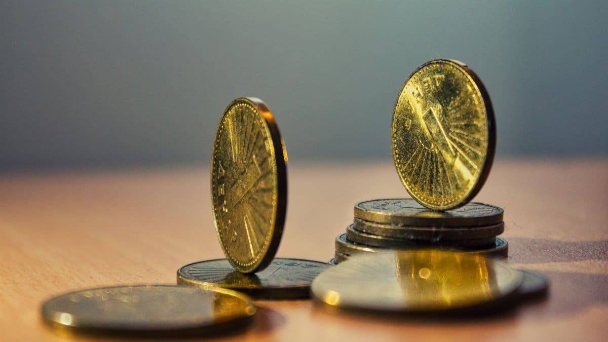 Close-up of North Macedonian denar coins on a bamboo table with artistic lighting.