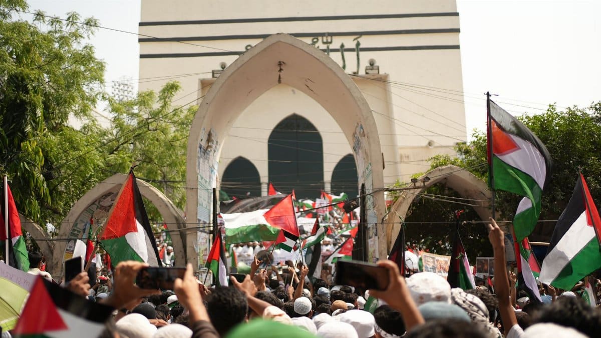A large pro-Palestinian protest in Dhaka, Bangladesh with flags and banners.