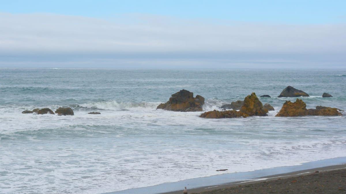 Serene ocean view capturing waves and rock formations along the Klamath coast, California.