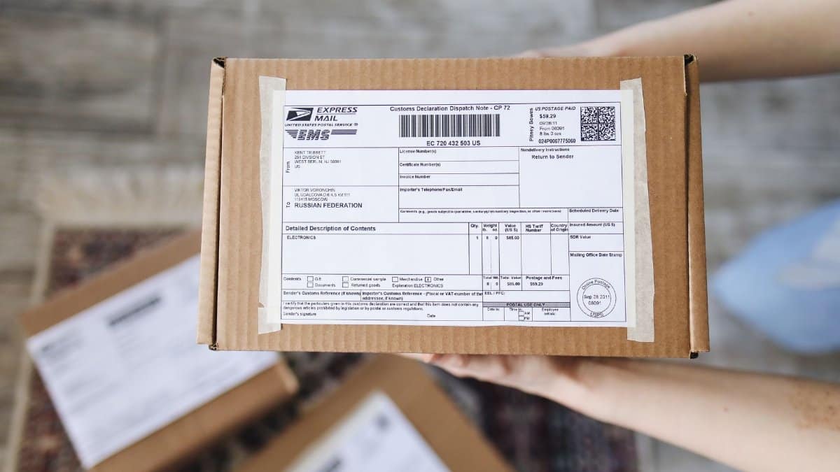 Top view of hands holding an express mail parcel with a customs declaration.