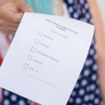 Close-up photo of a hand holding a US election voting ballot.