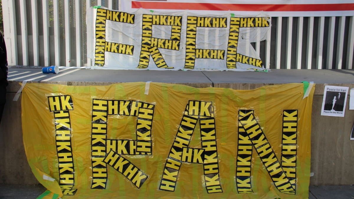 Vibrant protest banners advocating for human rights in Iran displayed outdoors, showcasing bold messages.