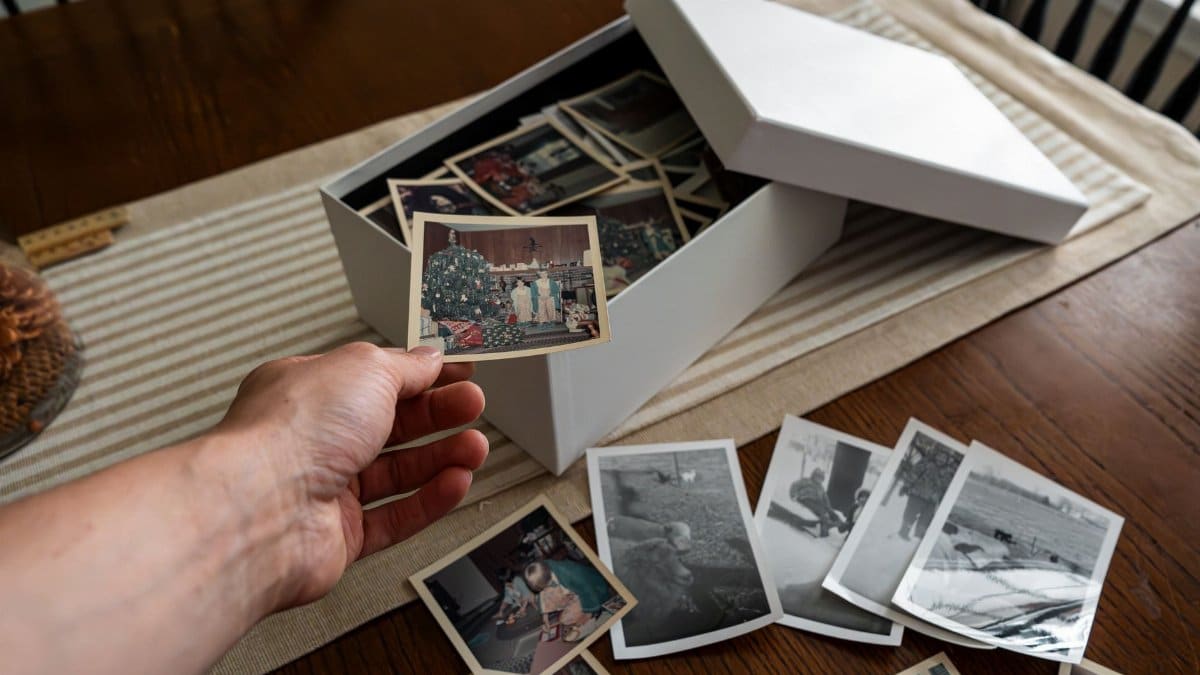 A hand holding a vintage photo from a nostalgic family photo collection.