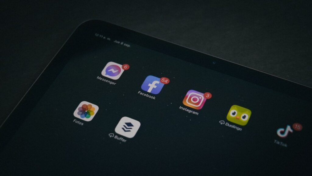 A tablet displaying popular apps like Facebook and Instagram in a dimly lit setting.