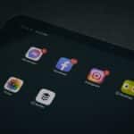 A tablet displaying popular apps like Facebook and Instagram in a dimly lit setting.