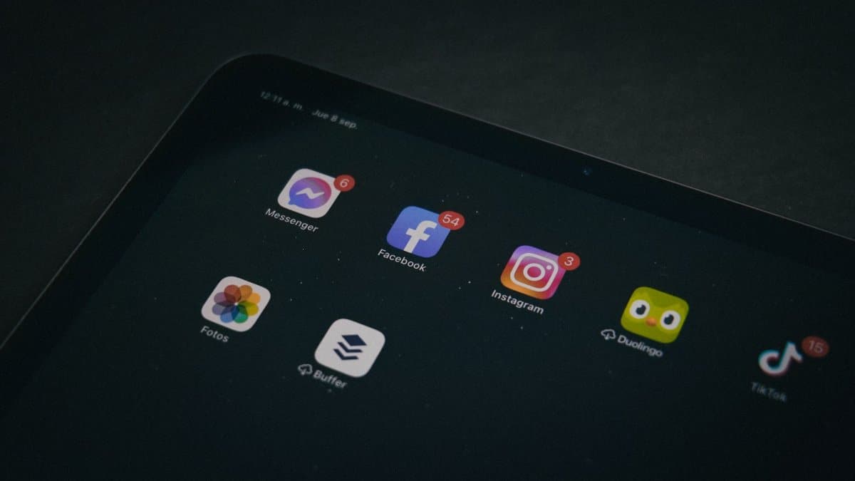 A tablet displaying popular apps like Facebook and Instagram in a dimly lit setting.
