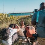 Behind-the-scenes of a beach photoshoot in Miami with photographers and a model.