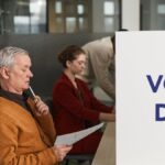 People voting indoors on election day, making decisions at a polling station.