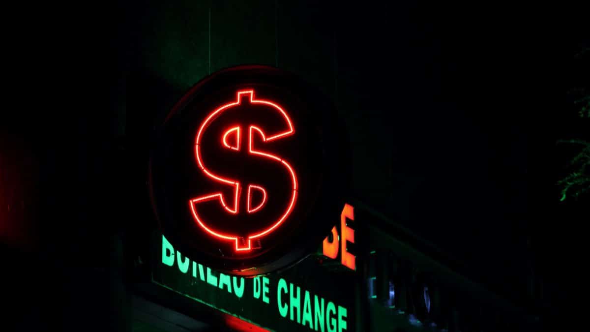 Close-up of a glowing red dollar sign neon at a currency exchange bureau.