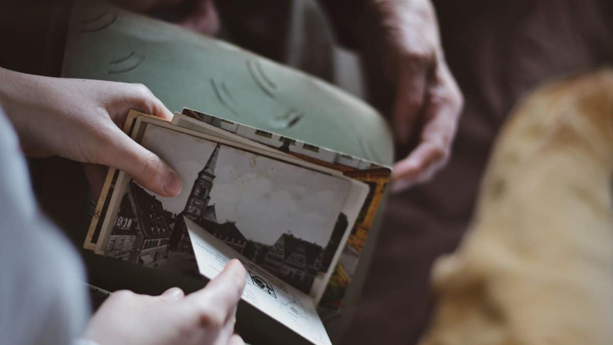 Two people sharing memories through black and white vintage postcards.