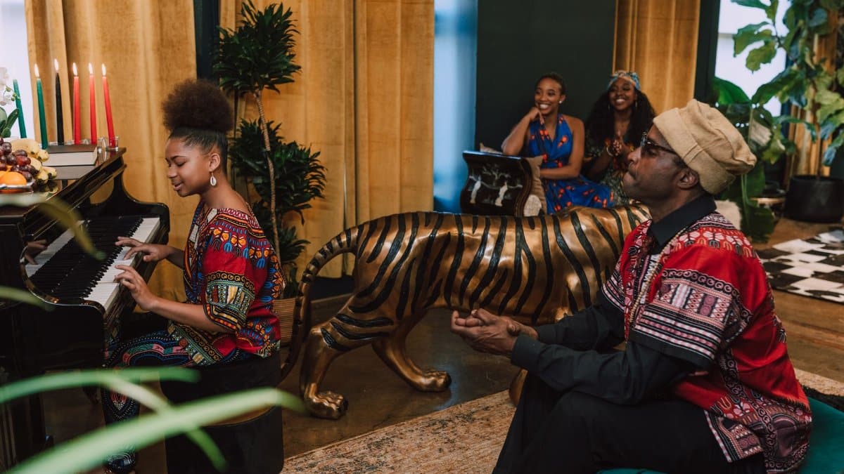 Joyous Kwanzaa celebration with traditional attire, music, and decorations.