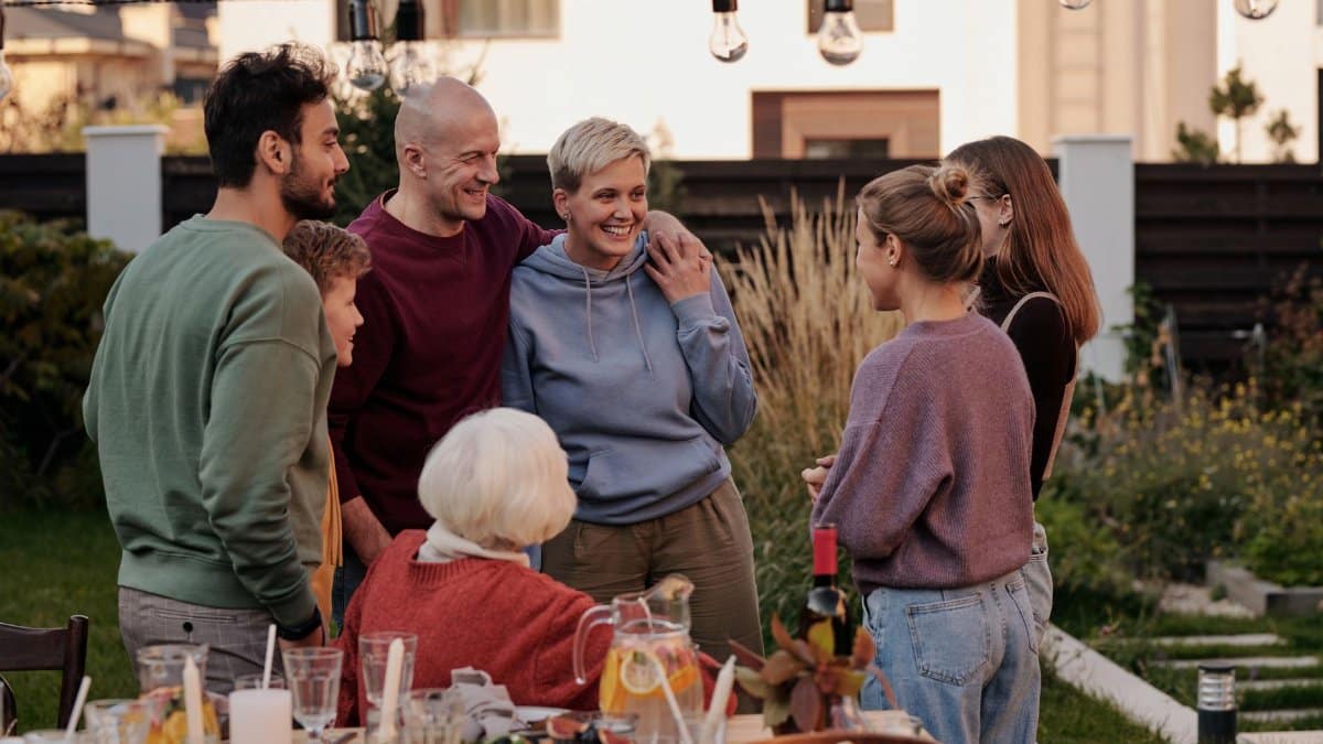 A joyful group of adults and seniors enjoying a lively garden get-together.