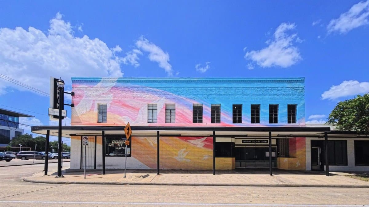 Bright mural on a building facade under clear blue skies in Houston, Texas.